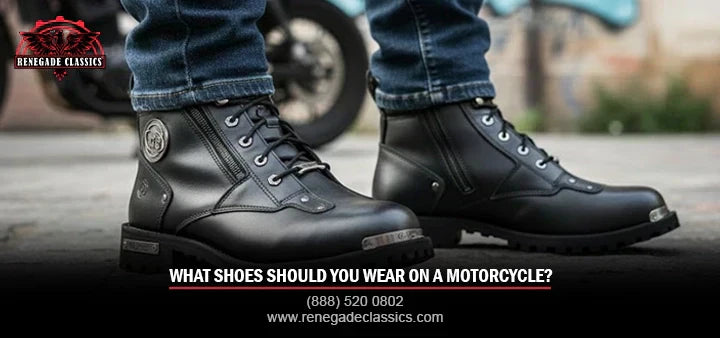 In this image, a man wearing black motorcycle boots with blue jeans stands on the road. The title “What Shoes Should You Wear on a Motorcycle?” with number  (888) 520-0802 and www.renegadeclassics.com is shown.